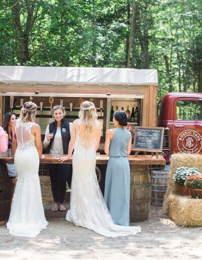 Brides and wedding guest being serviced beer at rustic taps truck